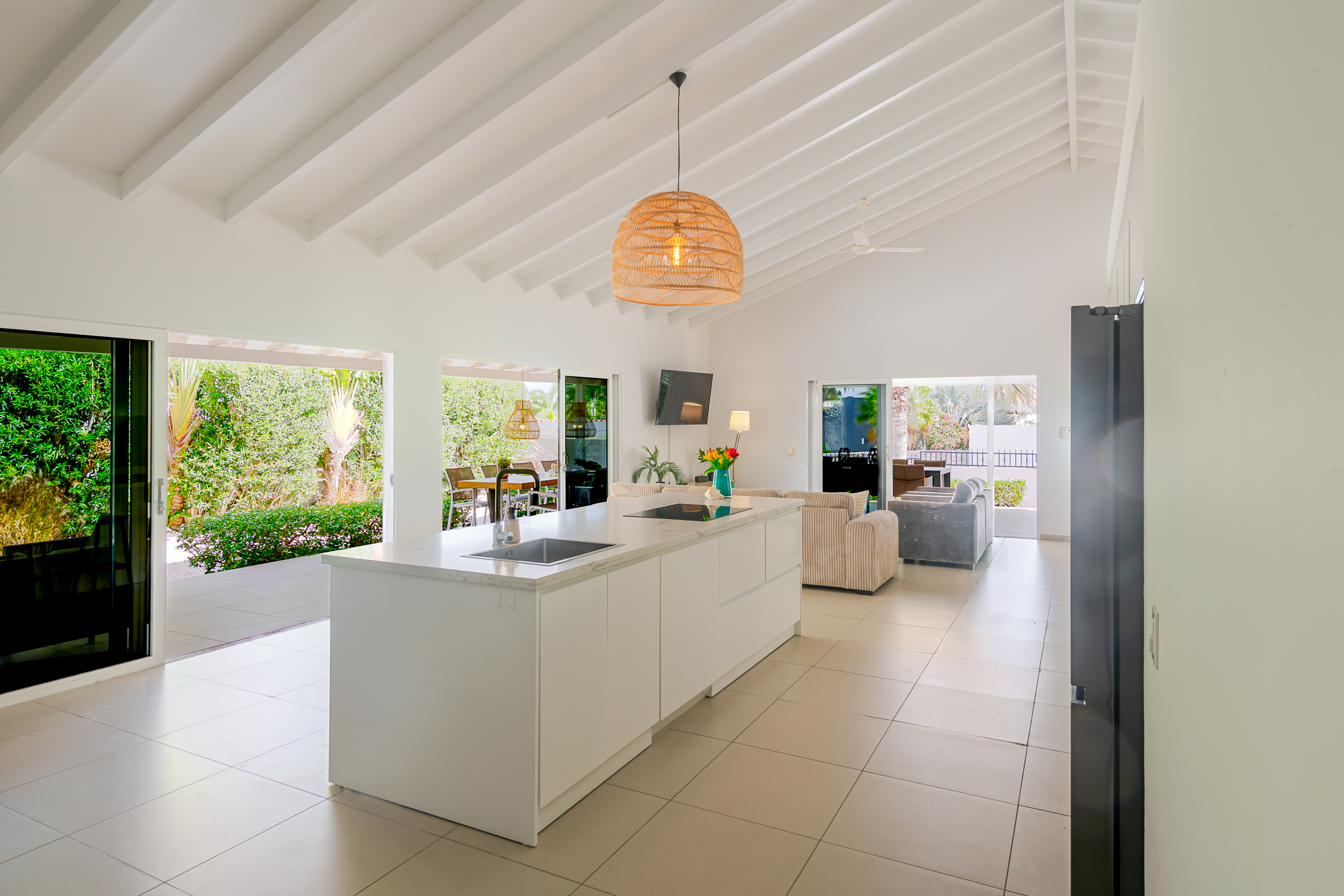 Open kitchen with cooking island and bar stools at Villa Curoyal